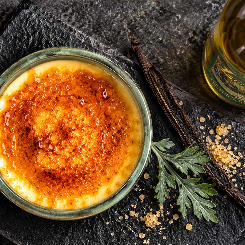 Absinth-Crème-brûlée mit karamellisierter Zuckerkruste, Vanille und Wermut